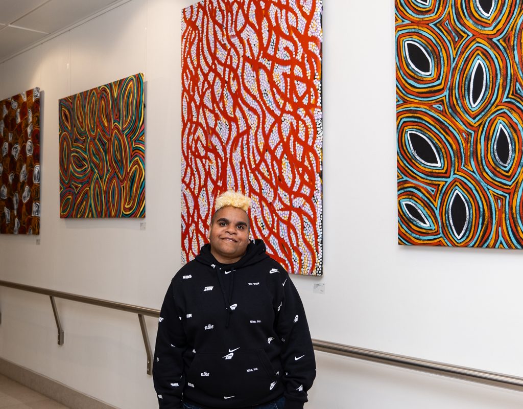 Photo of Jackie Saunders in front of her work