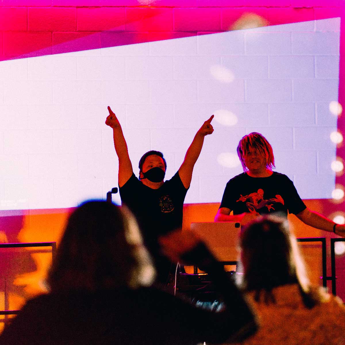 Photo of two DJs gesturing to the crowd