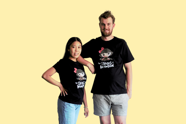 Two people wearing black t-shirt with The Sisters of Invention logo featuring a doll's head in black paint.
