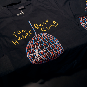 A black cotton t-shirt with large Heart Beat Club logo in colour on the front.