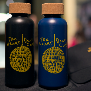 Black and navy water bottles with the Heart Beat Club logo in yellow