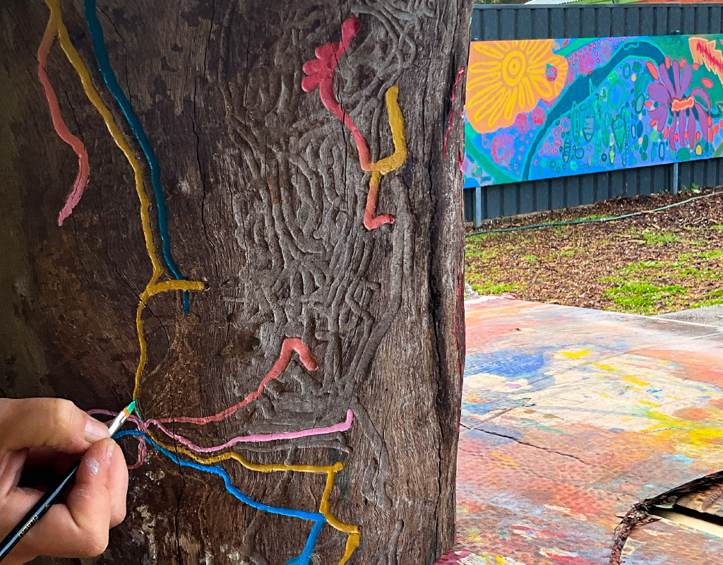 Etching on tree being painted in front of Barossa mural created for Inside Out
