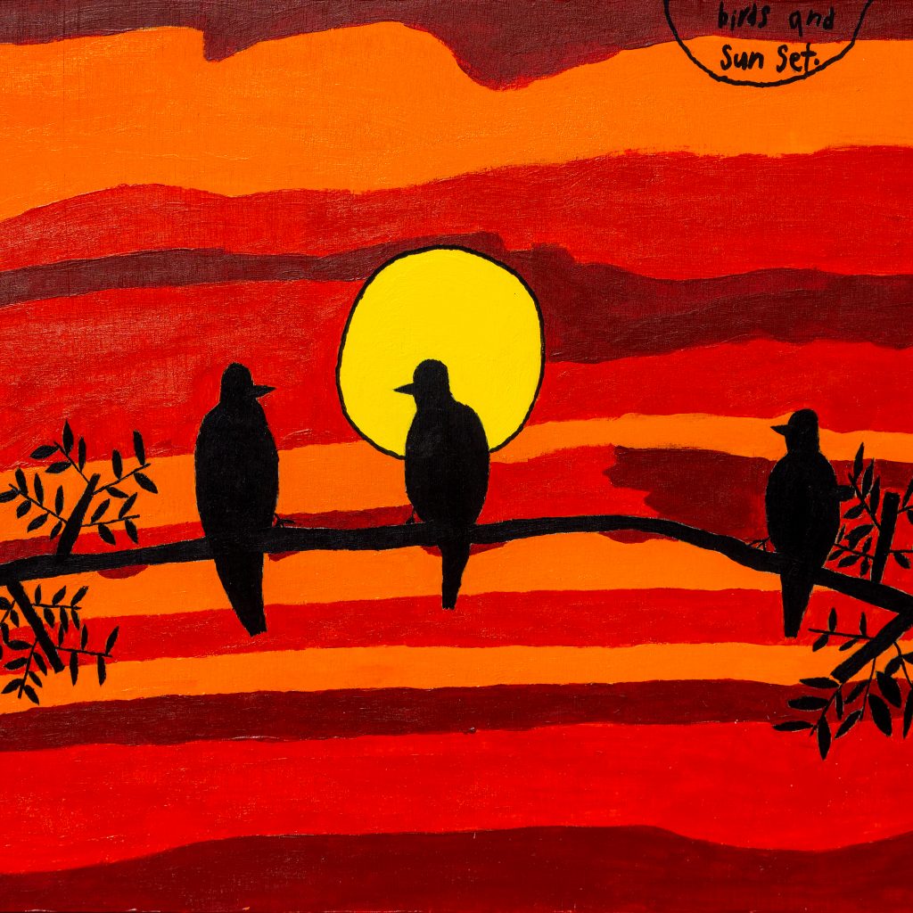 The silhouette of four birds perched on a branch at sunset. The sun is bright yellow and setting in a stripy red tones sky.