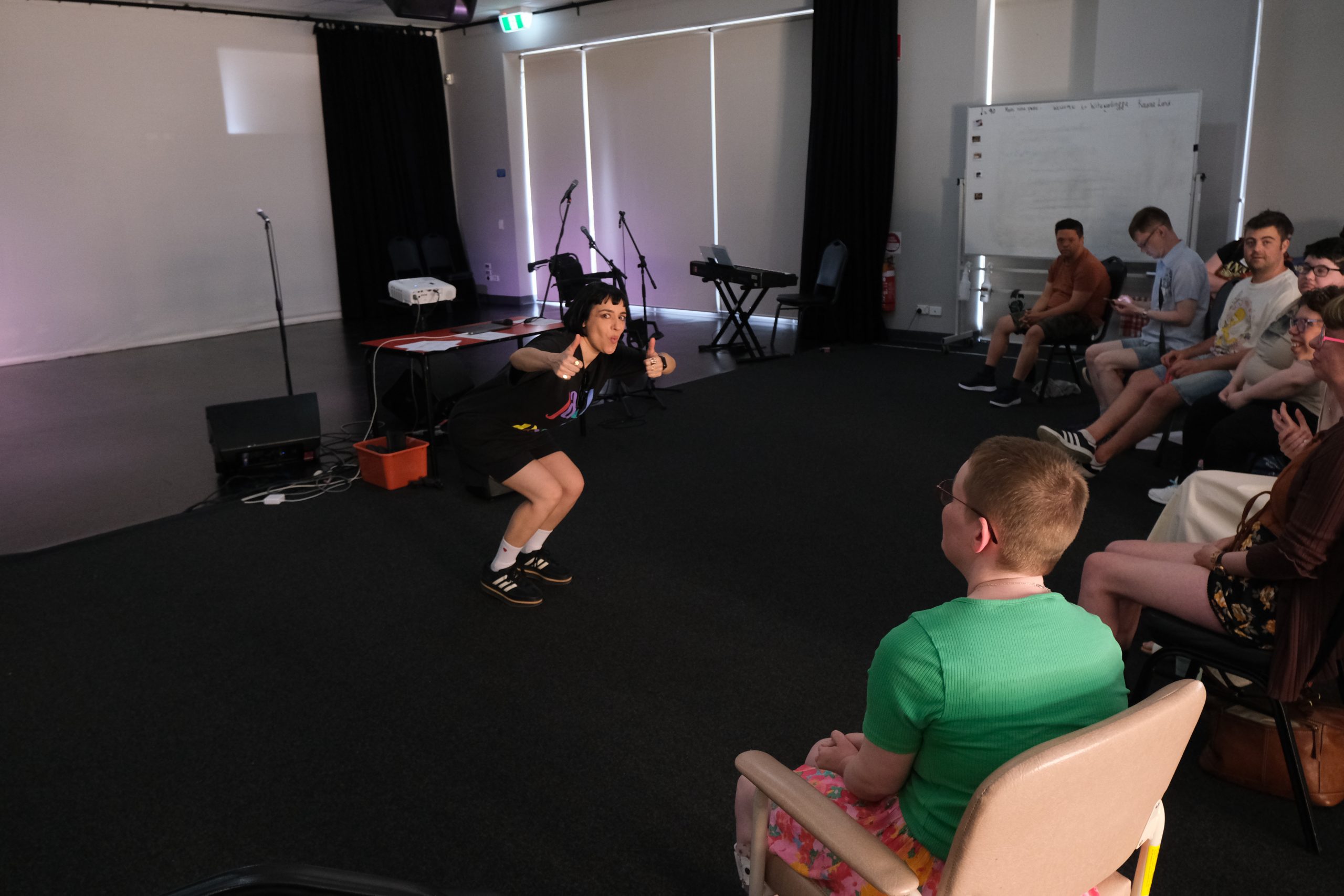 Carla Lipis posing with two thumbs up at the camera as part of a creative development workshop. 