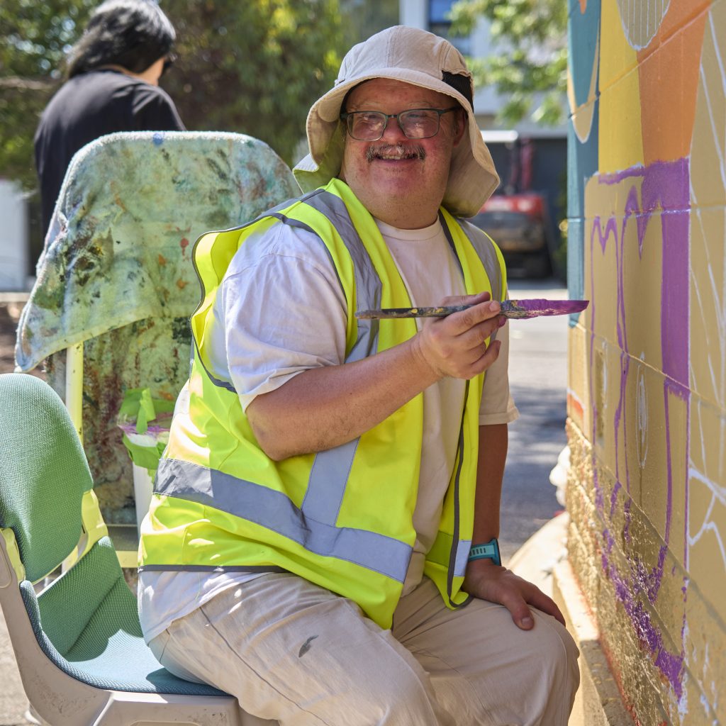 Nathan Dolphin painting the signal hut and turning toward the camera to smile.